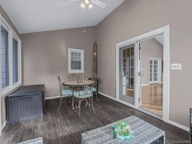 a dining room with wooden floor a glass table and chairs