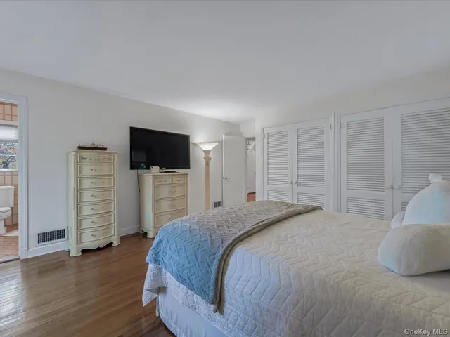 a spacious bedroom with a bed and a television in it