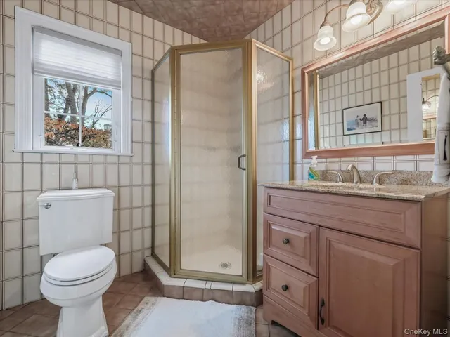 a bathroom with a granite countertop toilet a sink and a mirror