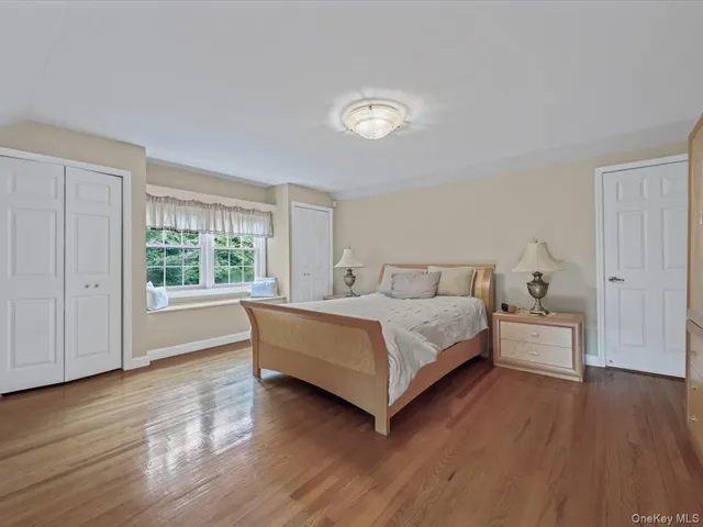 a spacious bedroom with a bed and a wooden floor