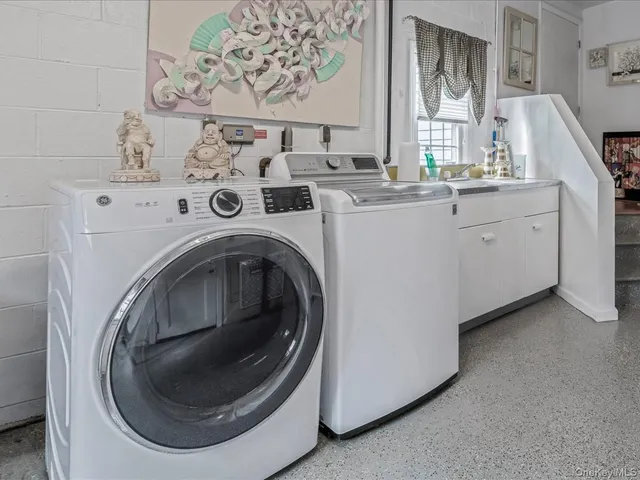 a utility room with sink dryer and washer