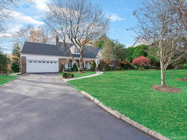 a view of a house with a big yard and large tree