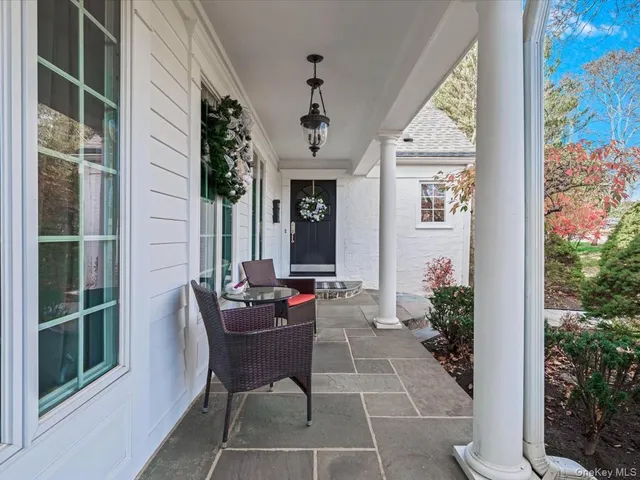 a view of a porch with chairs and potted plants
