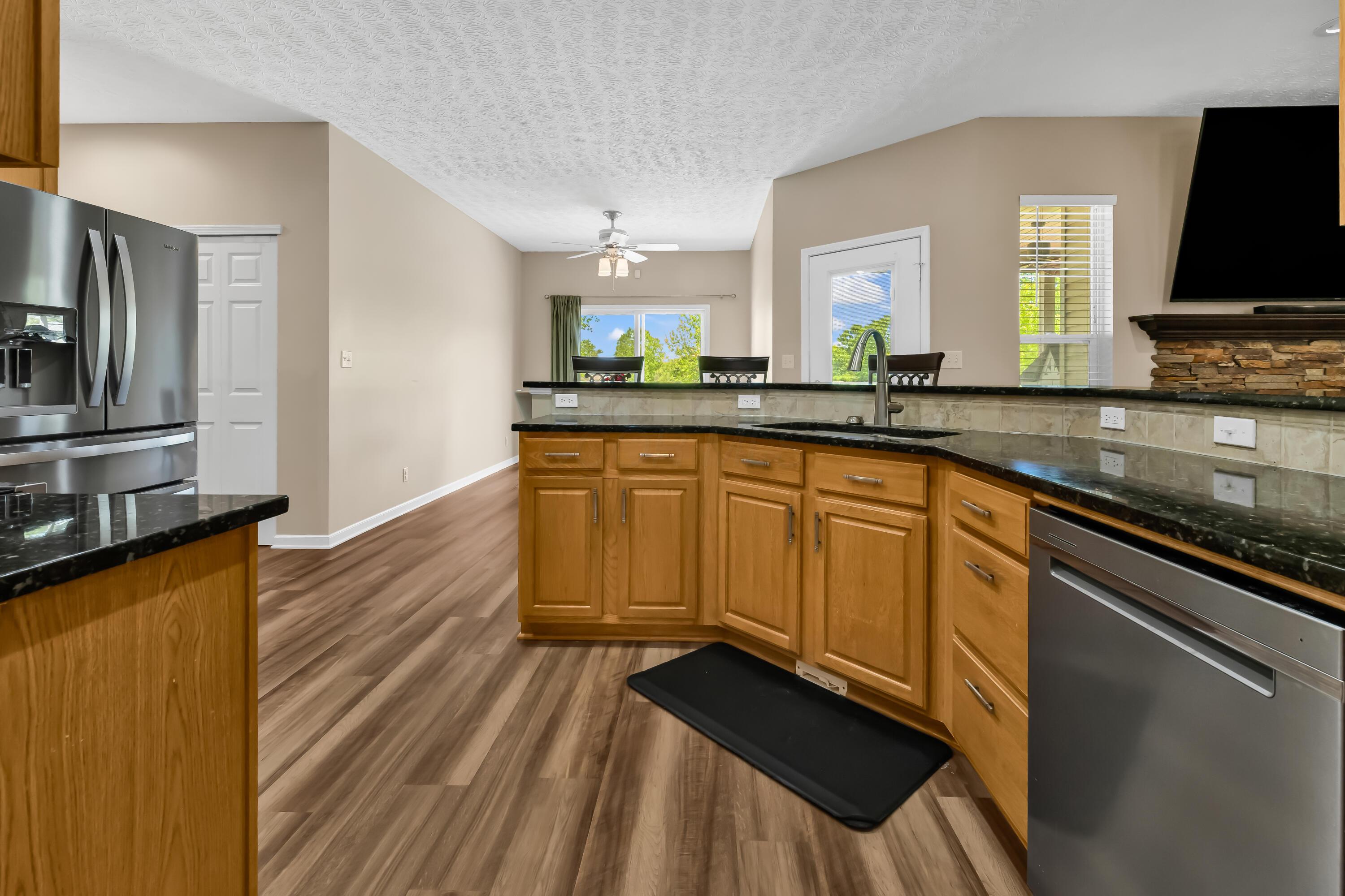 14396 Blamer Road Johnstown, OH 43031 - Photo 16 of 48 • Luxury vinyl plank flooring
• Tan painted walls
• Granite countertops
• New Whirlpool® refrigerator
~ 2025
• New Whirlpool® microwave
~ 2025
• New Whirlpool® electric
range ~ 2025
• New Whirlpool® dishwasher
~ 2025
• Peninsula with breakfast bar
ledge
• Double bowl, stainless steel
sink with sprayer
• New disposal ~ 2026
• Tile backsplash
• Raised panel cabinets