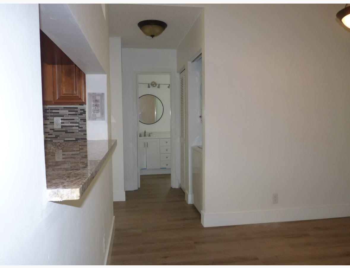 3130 Millwood Terrace, Unit 2120 Boca Raton, FL 33431 - Photo 4 of 15 a view of a hallway with wooden floor and staircase