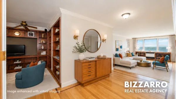 a living room with furniture a flat screen tv and a floor to ceiling window