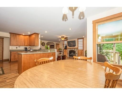389 Turnpike Road Ashby, MA 01431 - Photo 11 of 30 a large white kitchen with kitchen island a large counter top space a sink stainless steel appliances and cabinets