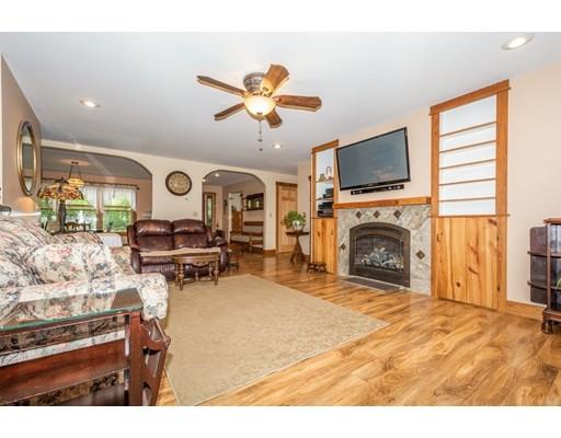 389 Turnpike Road Ashby, MA 01431 - Photo 8 of 30 a living room with furniture a fireplace and a flat screen tv