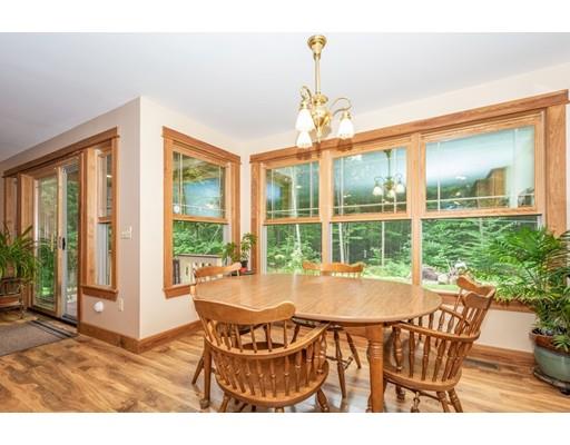 389 Turnpike Road Ashby, MA 01431 - Photo 10 of 30 a dining room with furniture a chandelier and wooden floor