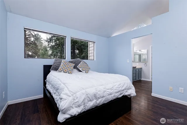 a bedroom with a large bed and wooden floor