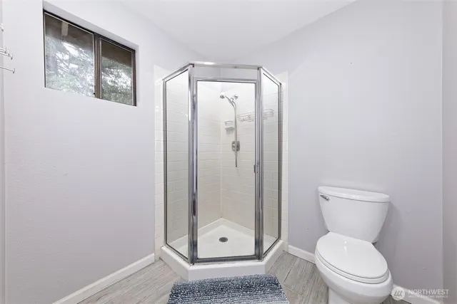 a bathroom with a toilet and a shower