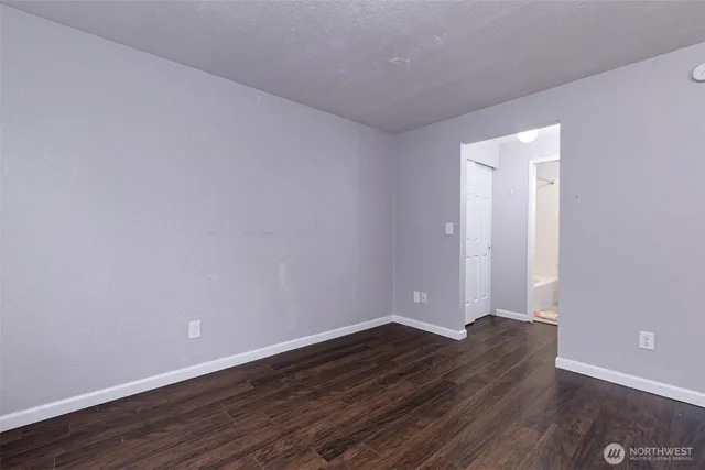 a view of an empty room with wooden floor