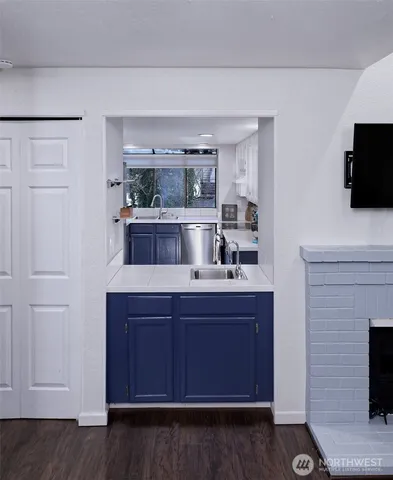 a kitchen with a sink and wooden floor