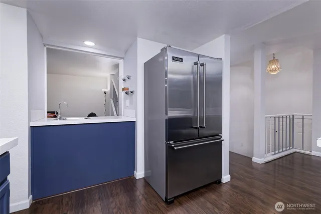 a kitchen with granite countertop a refrigerator and a sink
