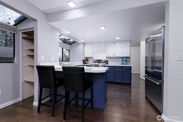 a kitchen with a dining table chairs refrigerator and cabinets