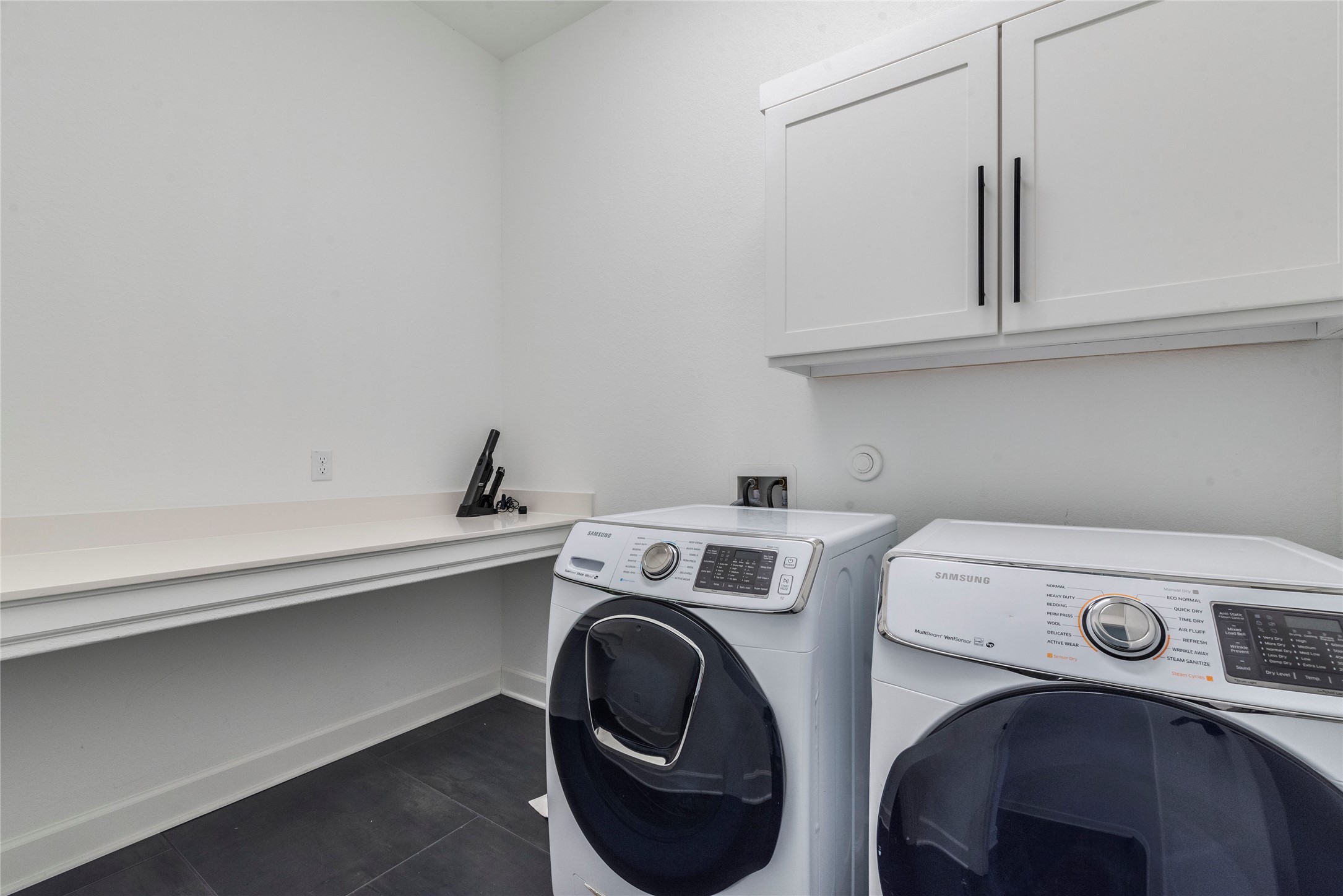 231 Call Drive Austin, TX 78737 - Photo 31 of 40 Laundry area featuring cabinet space, separate washer and dryer, and dark tile patterned flooring