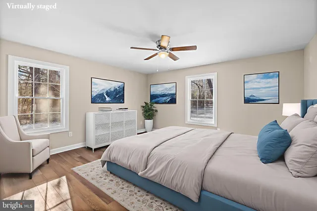 a bedroom with a large bed a chandelier and windows