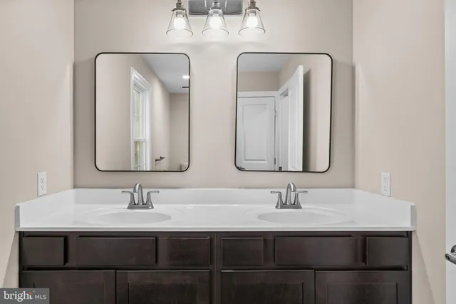 a bathroom with double vanity sinks and a mirror