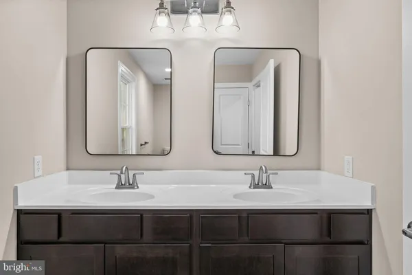 a bathroom with double vanity sinks and a mirror
