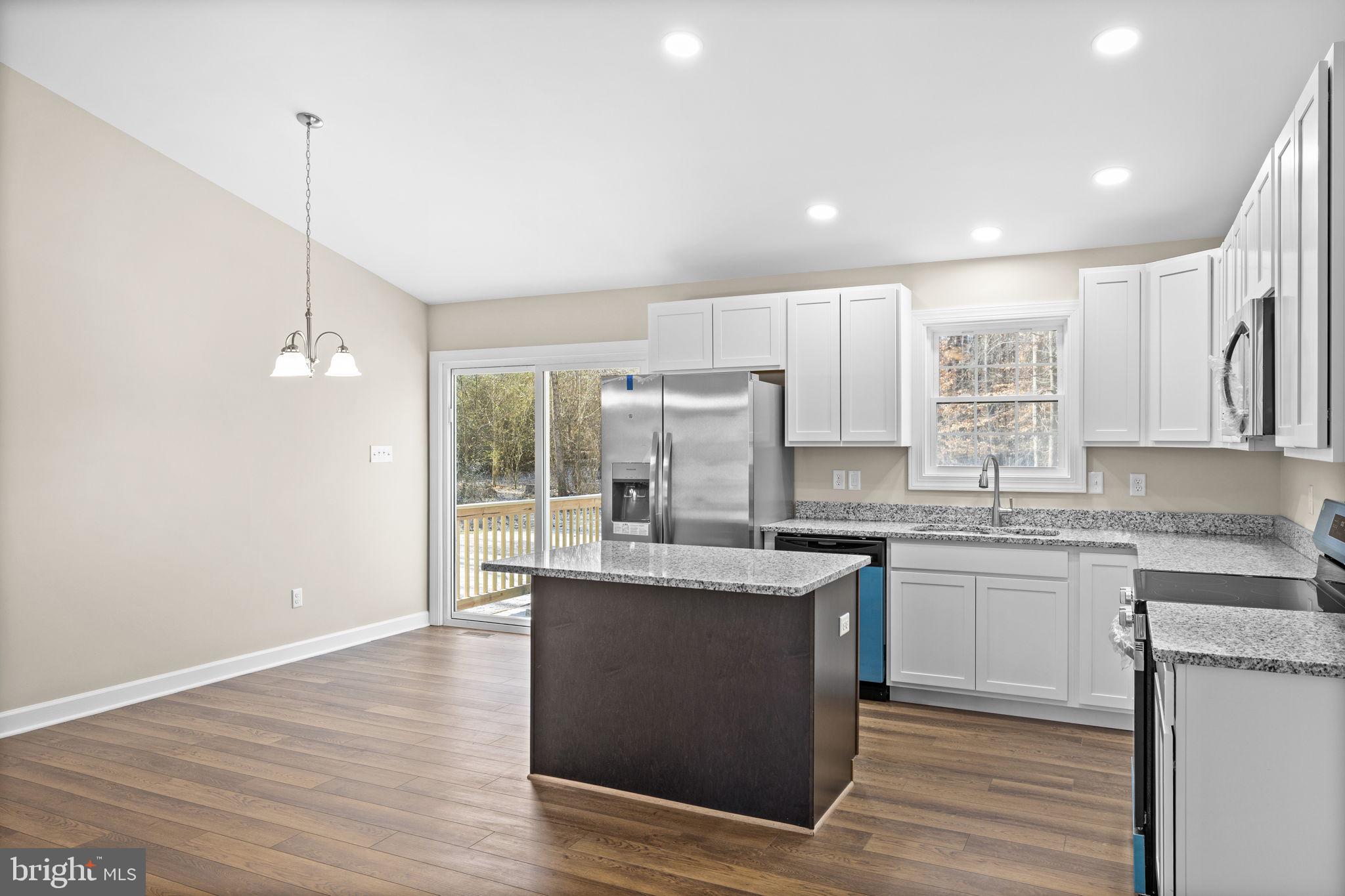 18078 Monrovia Road Orange, VA 22960 - Photo 32 of 49 a kitchen with kitchen island granite countertop a sink cabinets and wooden floor