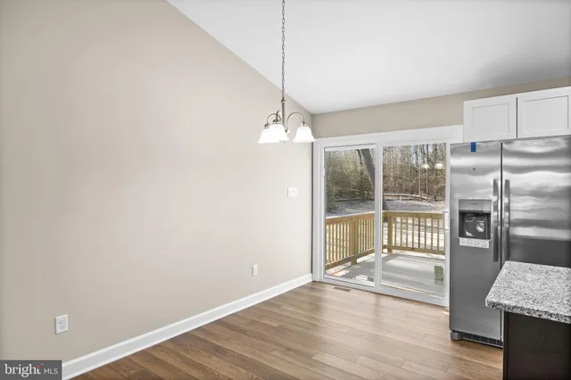 a view of a room with wooden floor and a floor to ceiling window