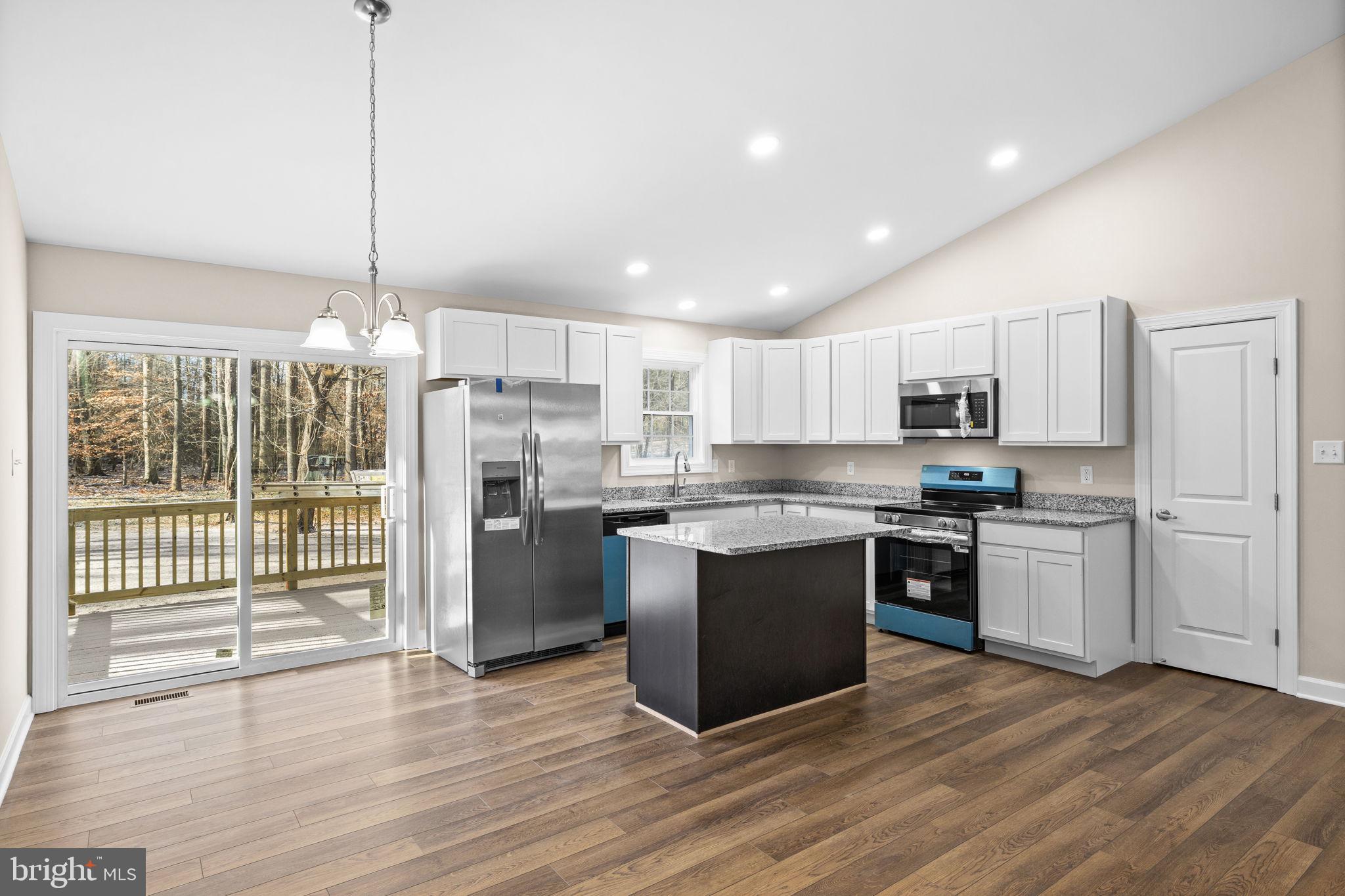 18078 Monrovia Road Orange, VA 22960 - Photo 4 of 49 a kitchen with stainless steel appliances granite countertop a refrigerator a sink dishwasher a stove and white cabinets with wooden floor