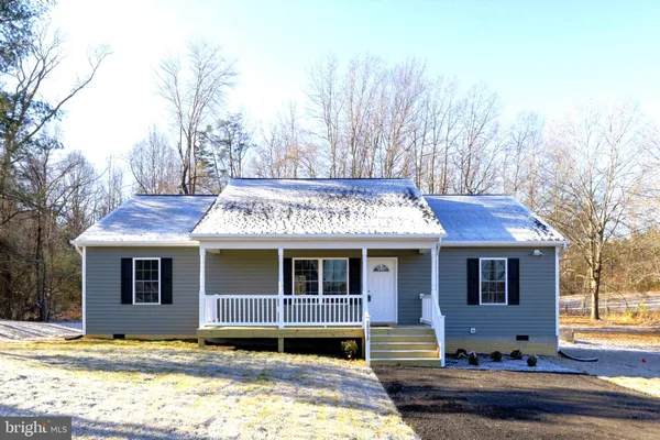 a front view of a house with a garden and patio