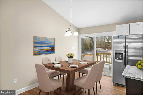 a dining room with furniture a chandelier and wooden floor