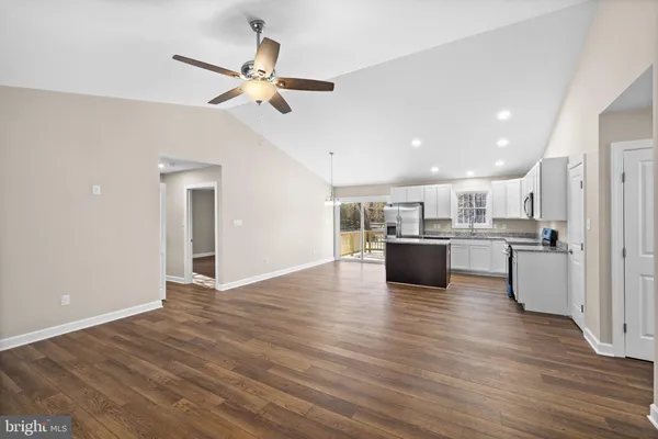 a view of kitchen with kitchen island wooden floor center island and appliances