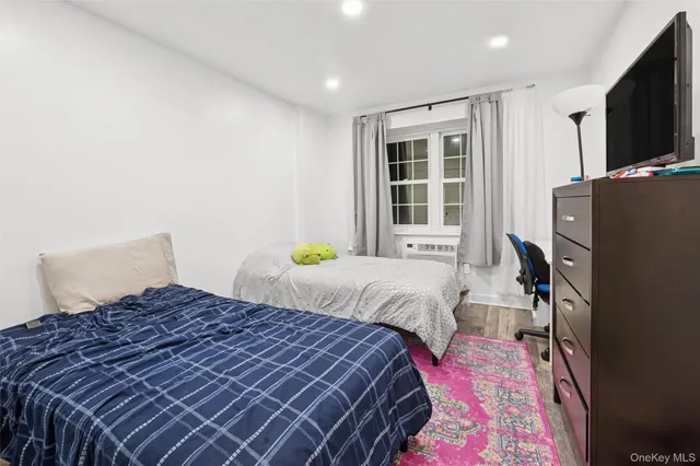 a bedroom with a large bed and a flat tv screen on dresser