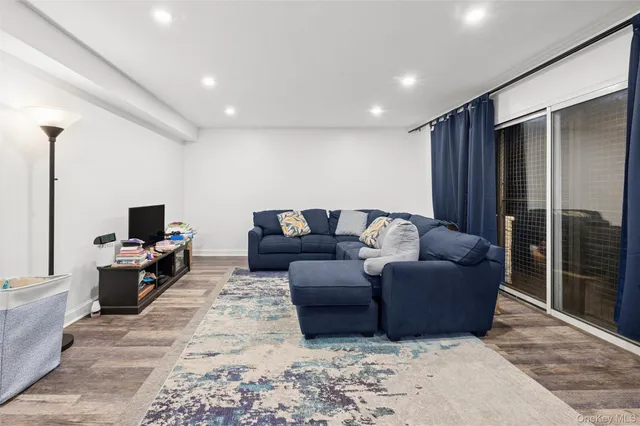 a living room with furniture a flat screen tv and a large window