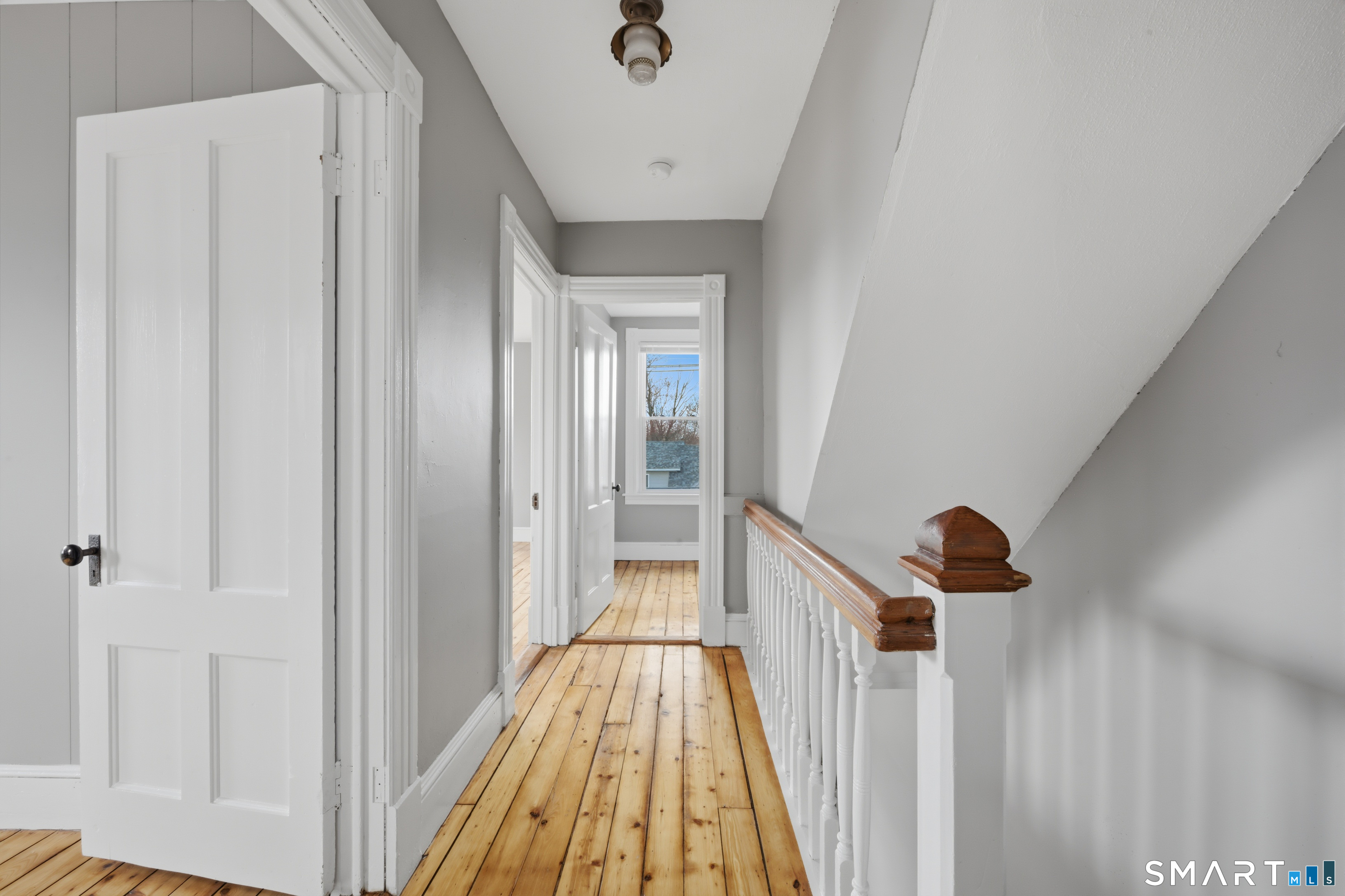43 Dunham Street Norwich, CT 06360 - Photo 15 of 26 a view of a hallway with wooden floor and staircase