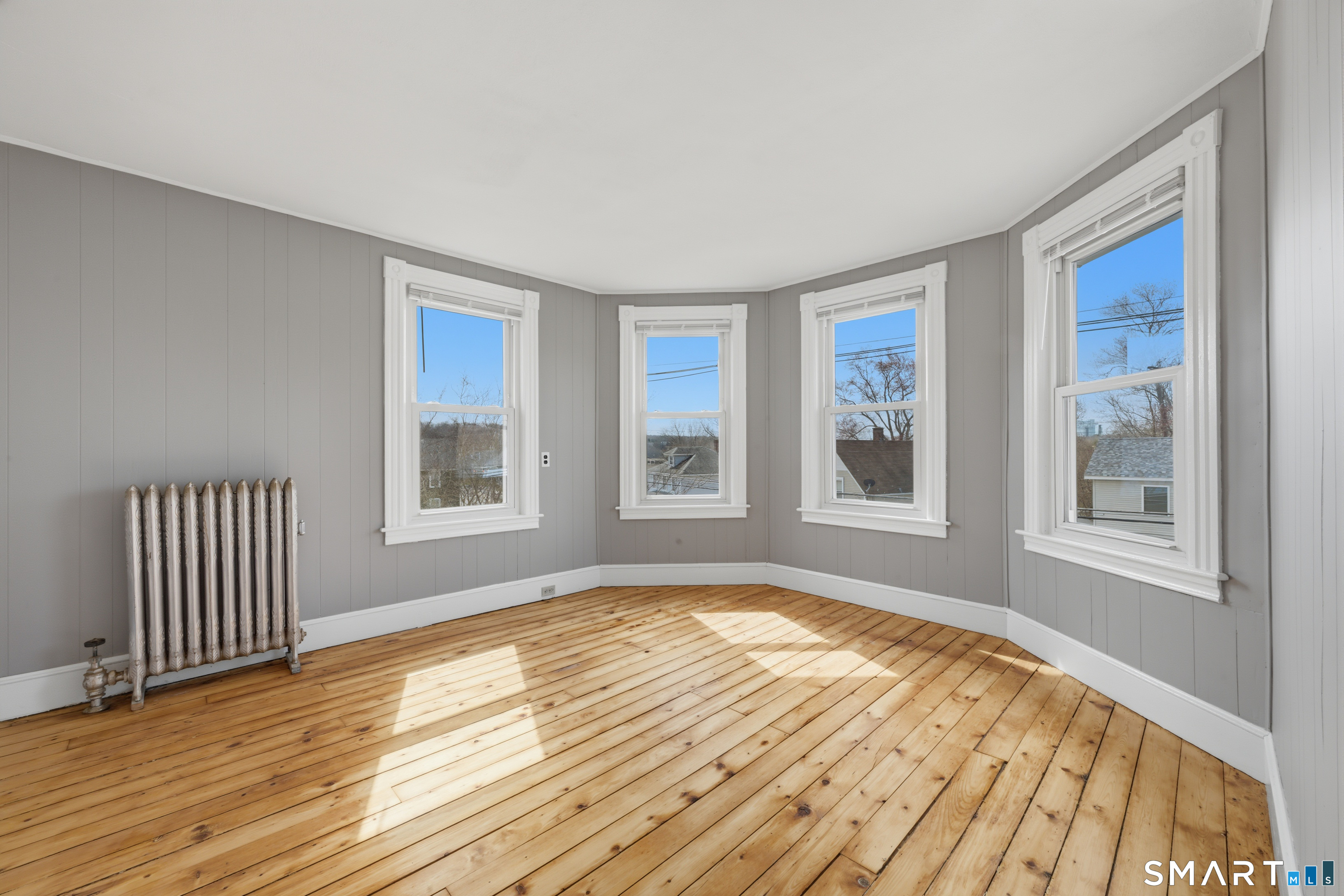 43 Dunham Street Norwich, CT 06360 - Photo 18 of 26 a view of an empty room with wooden floor and a window