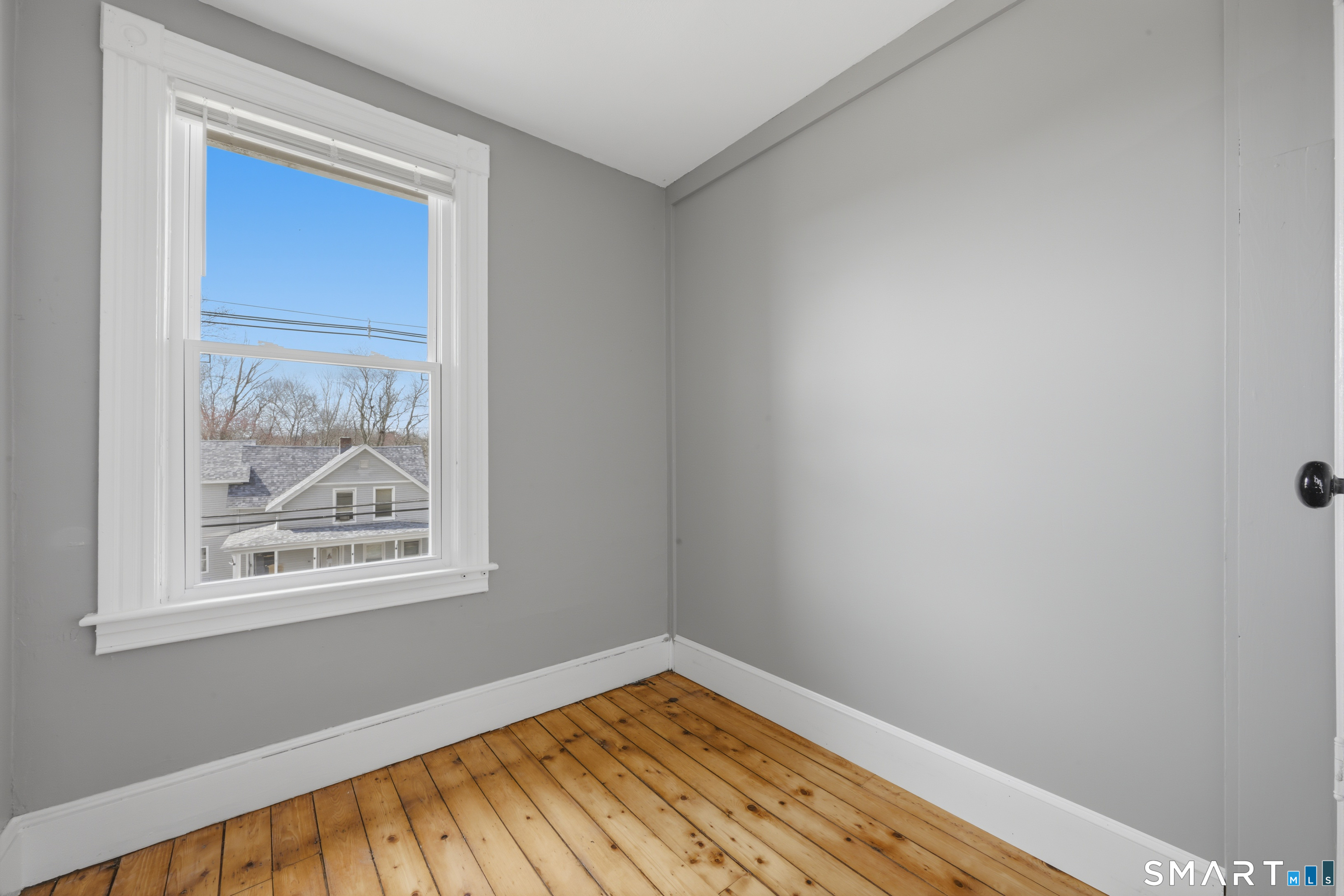 43 Dunham Street Norwich, CT 06360 - Photo 20 of 26 a view of empty room with window and wooden floor