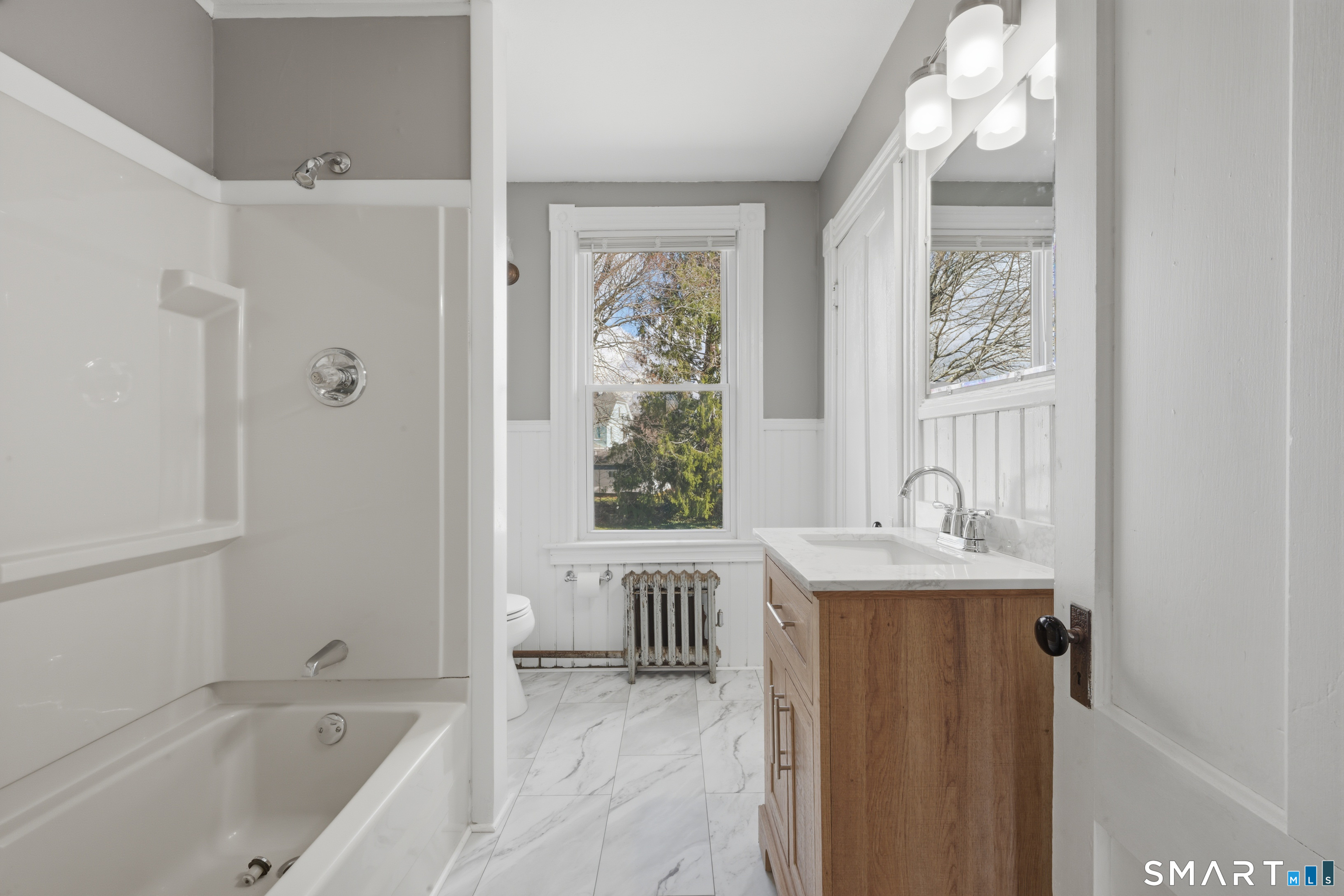 43 Dunham Street Norwich, CT 06360 - Photo 22 of 26 a bathroom with a bathtub a sink and a window