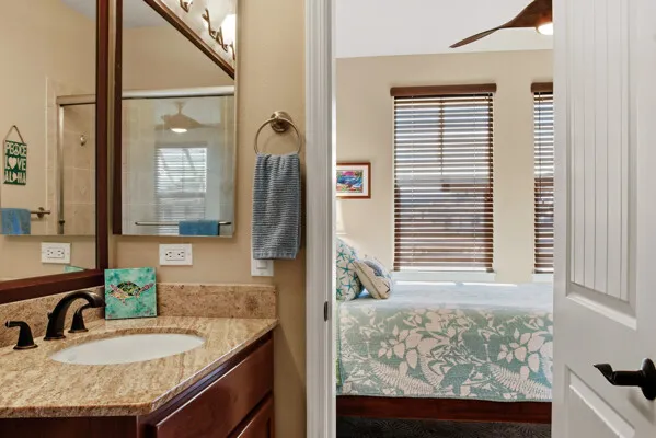 a bathroom with a granite countertop sink a mirror and shower