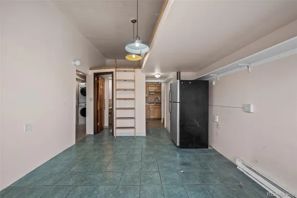a view of a storage & utility room with refrigerator and dishwasher cabinets