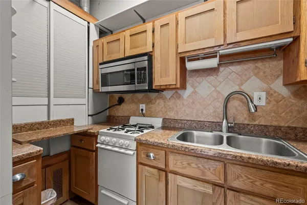 a kitchen with stainless steel appliances granite countertop a sink stove and microwave