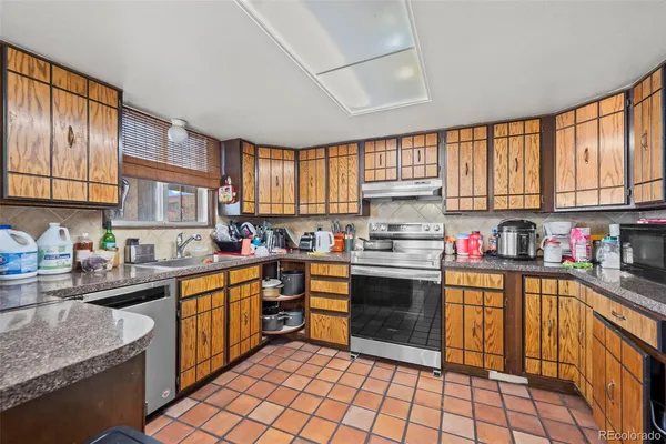 a kitchen with stainless steel appliances granite countertop a stove sink and cabinets