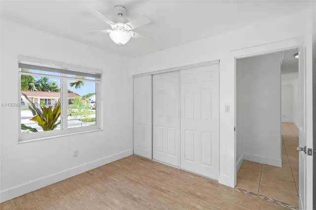 a view of an empty room with window and closet area
