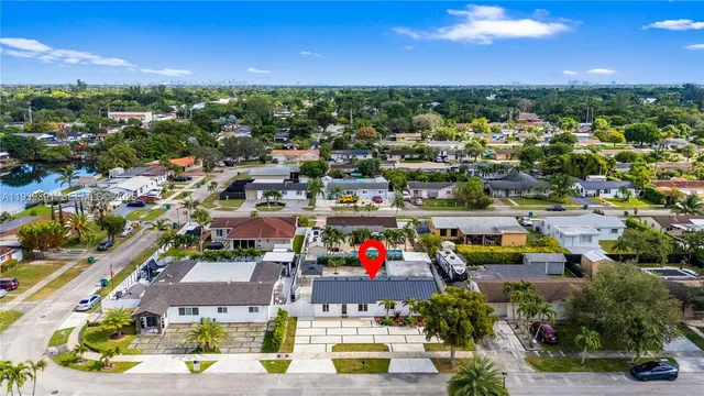 an aerial view of residential houses with outdoor space and ocean view