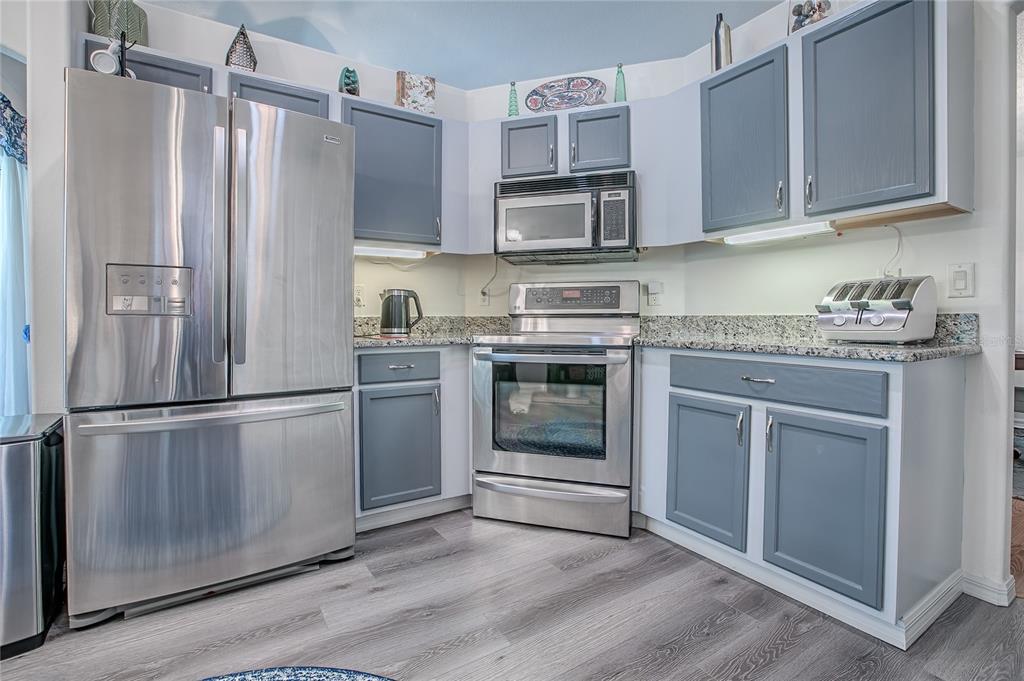 4802 Summerbridge Circle Leesburg, FL 34748 - Photo 14 of 67 a kitchen with stainless steel appliances granite countertop a refrigerator stove and sink