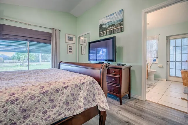 a bedroom with a bed a dresser and painting on the wall