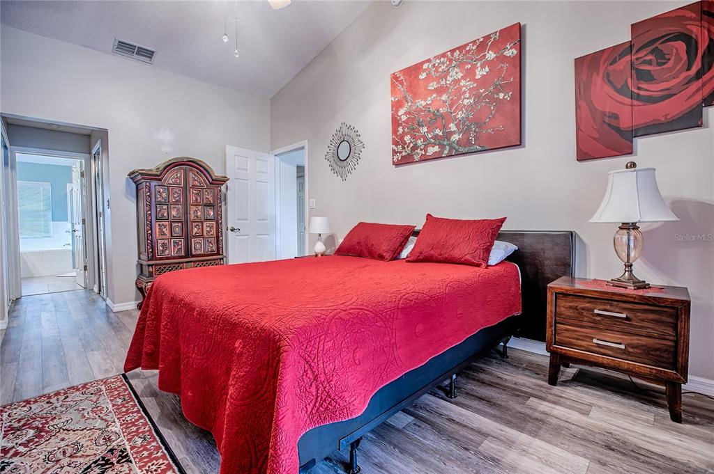 4802 Summerbridge Circle Leesburg, FL 34748 - Photo 32 of 67 a bedroom with a bed a dresser and painting on the wall