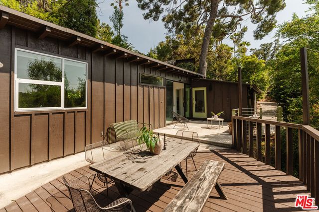 a view of a patio that has a table and chairs with wooden floor and fence