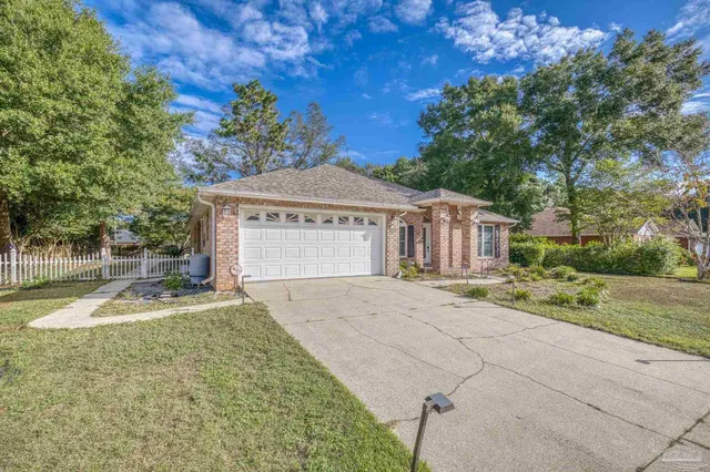 a view of a house with a yard and large tree