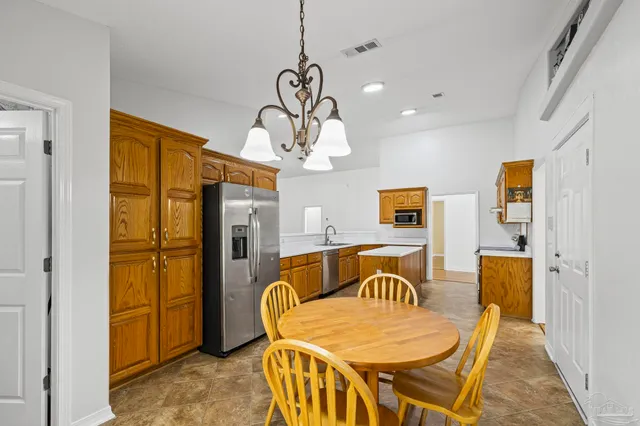 a dining room with wooden floor furniture and a chandelier