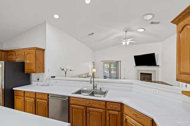 a kitchen with a sink and a flat screen tv