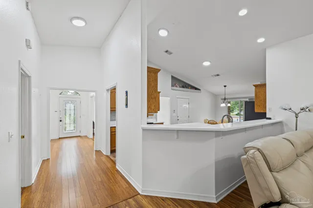 a living room with stainless steel appliances kitchen island granite countertop furniture and wooden floor