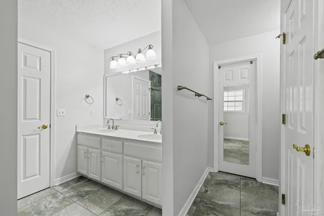 a spacious bathroom with a double vanity sink mirror and shower